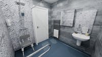 Spacious mobility wet room with level-access shower, chevron wall panels, wall-hung basin, grab rails, shower seat and anti-slip flooring in Shipley.