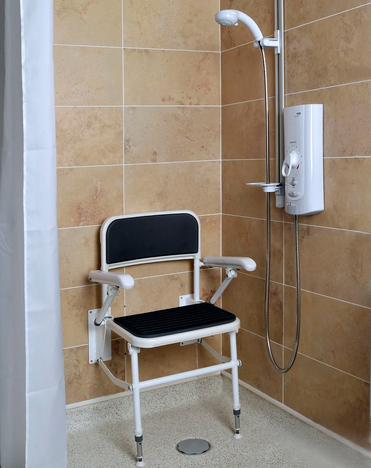 Disabled shower height example showing fold-down shower seat and accessible control positioning