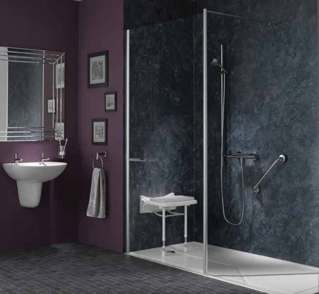 Contemporary accessible shower enclosure with grab rails and a fold-down shower seat designed to improve safety and independence.