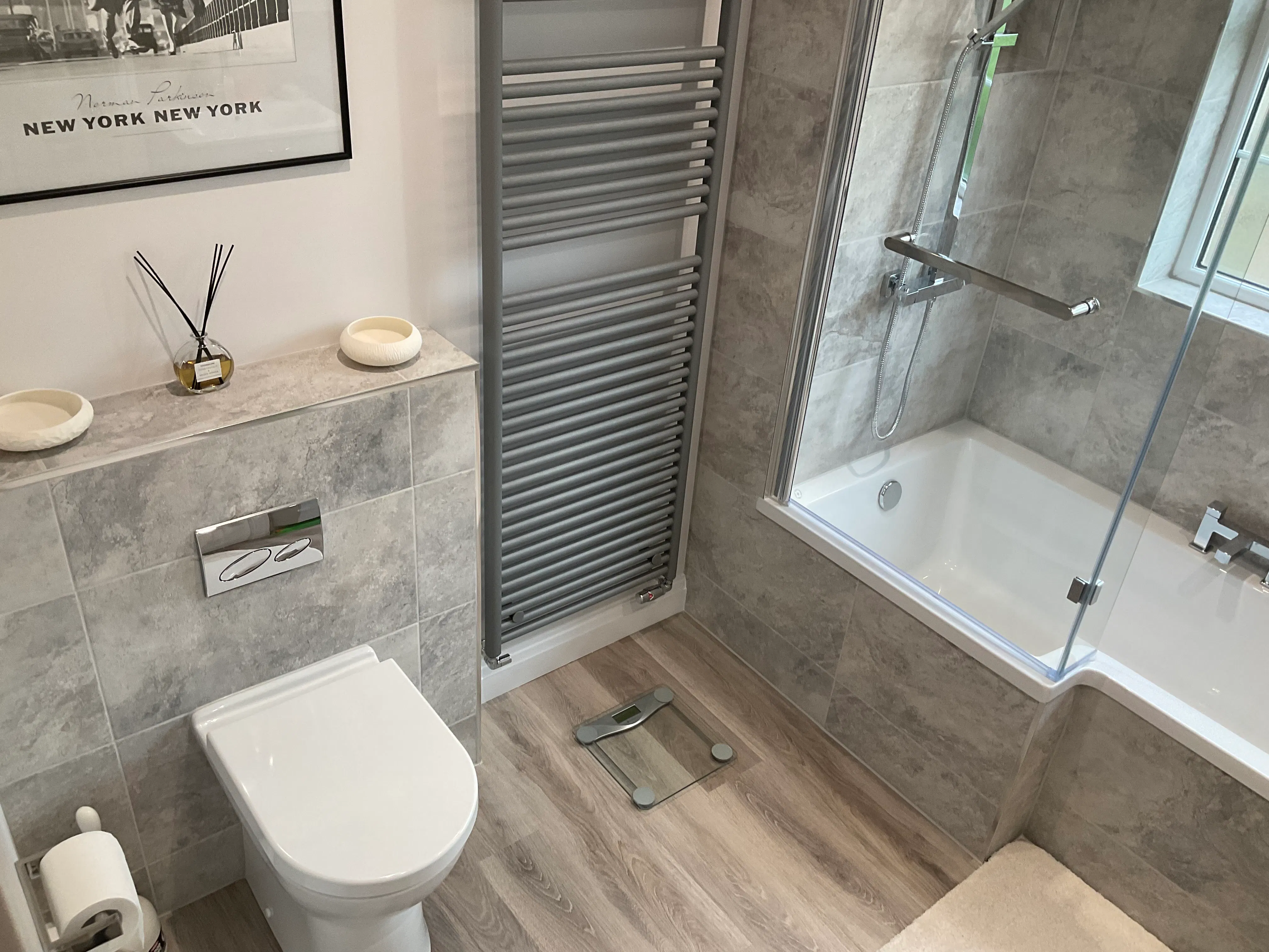 Bathroom with vertical radiator and bath showing integrated bathroom heating solution