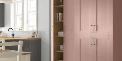 Soft pink Shaker pantry cupboards with open shelving and classic kitchen details