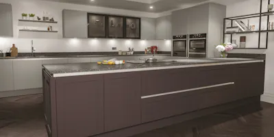 Spacious contemporary kitchen with oversized island, integrated ovens and minimalist cabinetry.