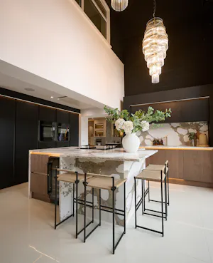 Contemporary open-plan kitchen and home office display at the More Kitchens Otley showroom, featuring an island with breakfast bar seating and integrated appliances.